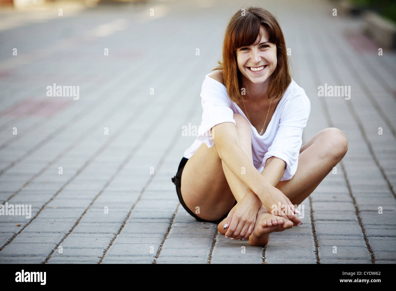 Joven chica desnuda sentada sobre el asfalto en el parque Fotografía de  stock - Alamy