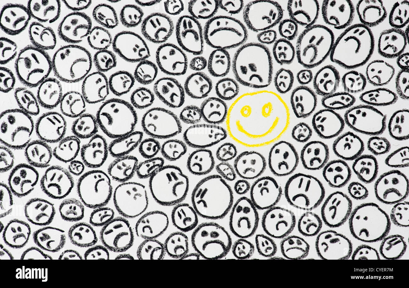 Lápiz de Cera el dibujo de una cara sonriente feliz entre dark rostros tristes. Concepto de depresión Foto de stock