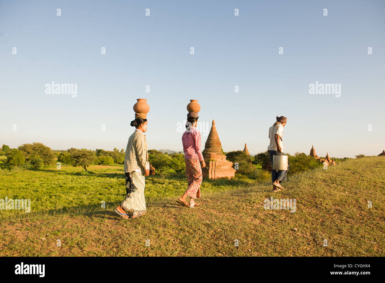 Los agricultores tradicionales en Myanmar, Bagan llevando ollas de vuelta a casa en bagan Foto de stock