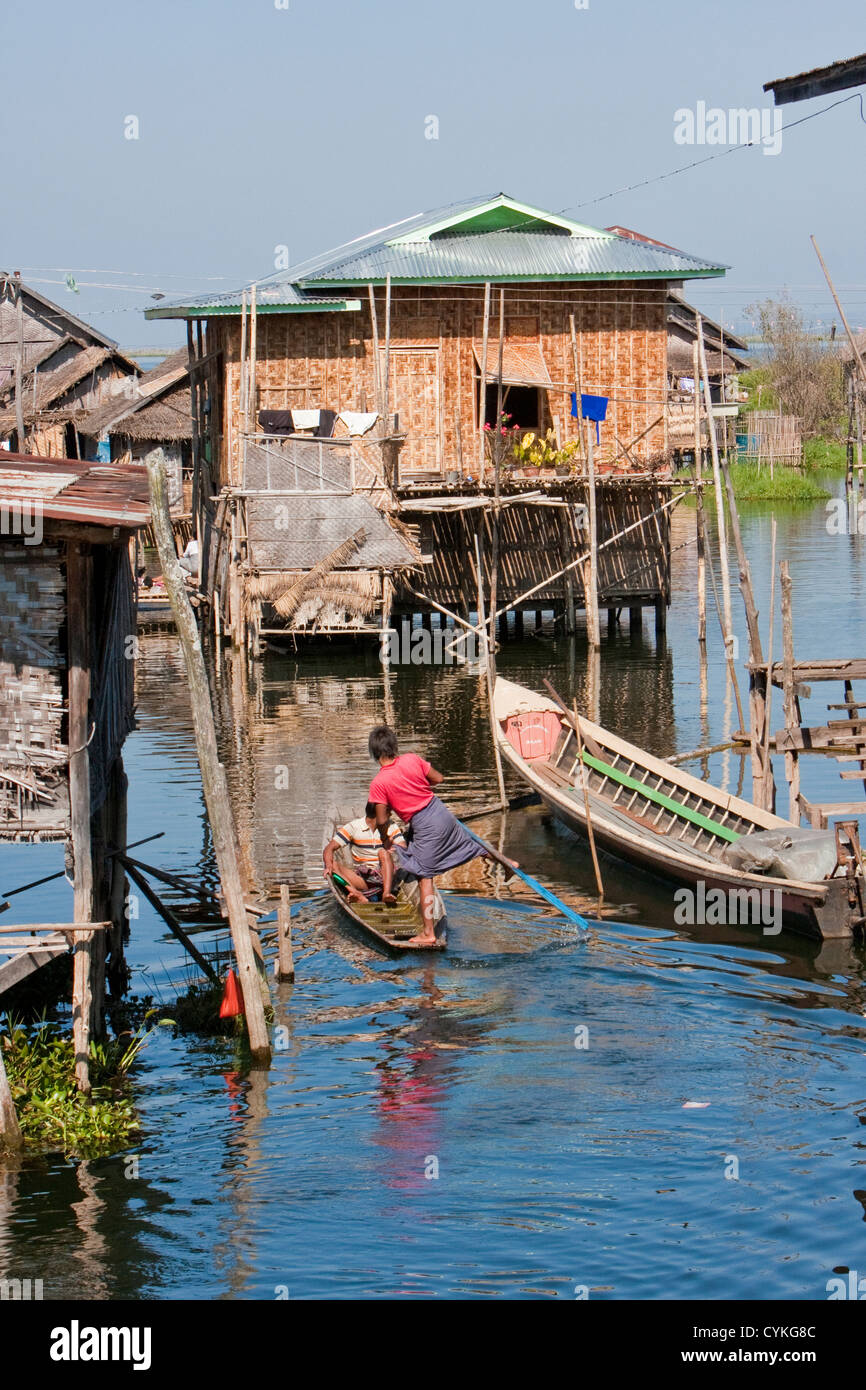 Myanmar, Birmania. Escena de aldea, casa sobre zancos, el transporte por barco, el Lago Inle, el Estado de Shan. Foto de stock