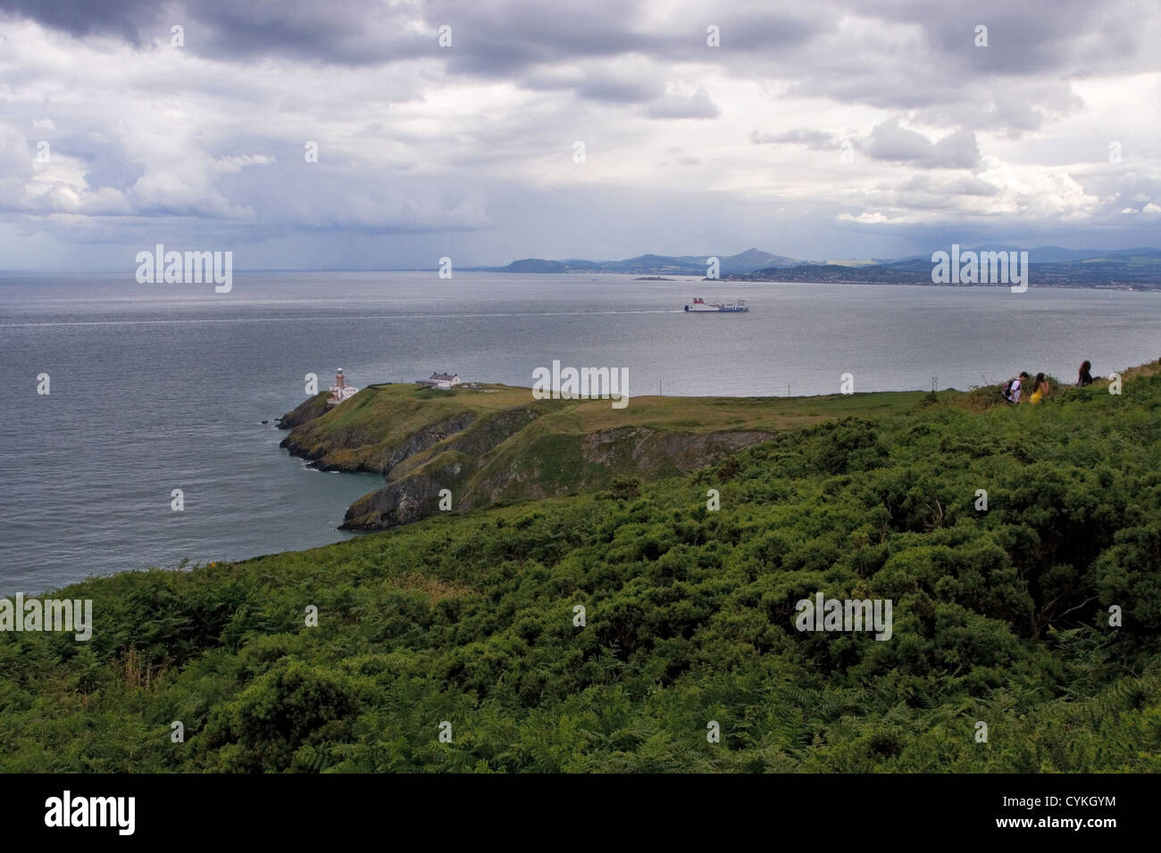 Howth con faro de Baily. En el fondo de la Bahía de Dublín, Dublín, Irlanda. UK ferry a Dublín (Stena Line) en segundo plano. Foto de stock