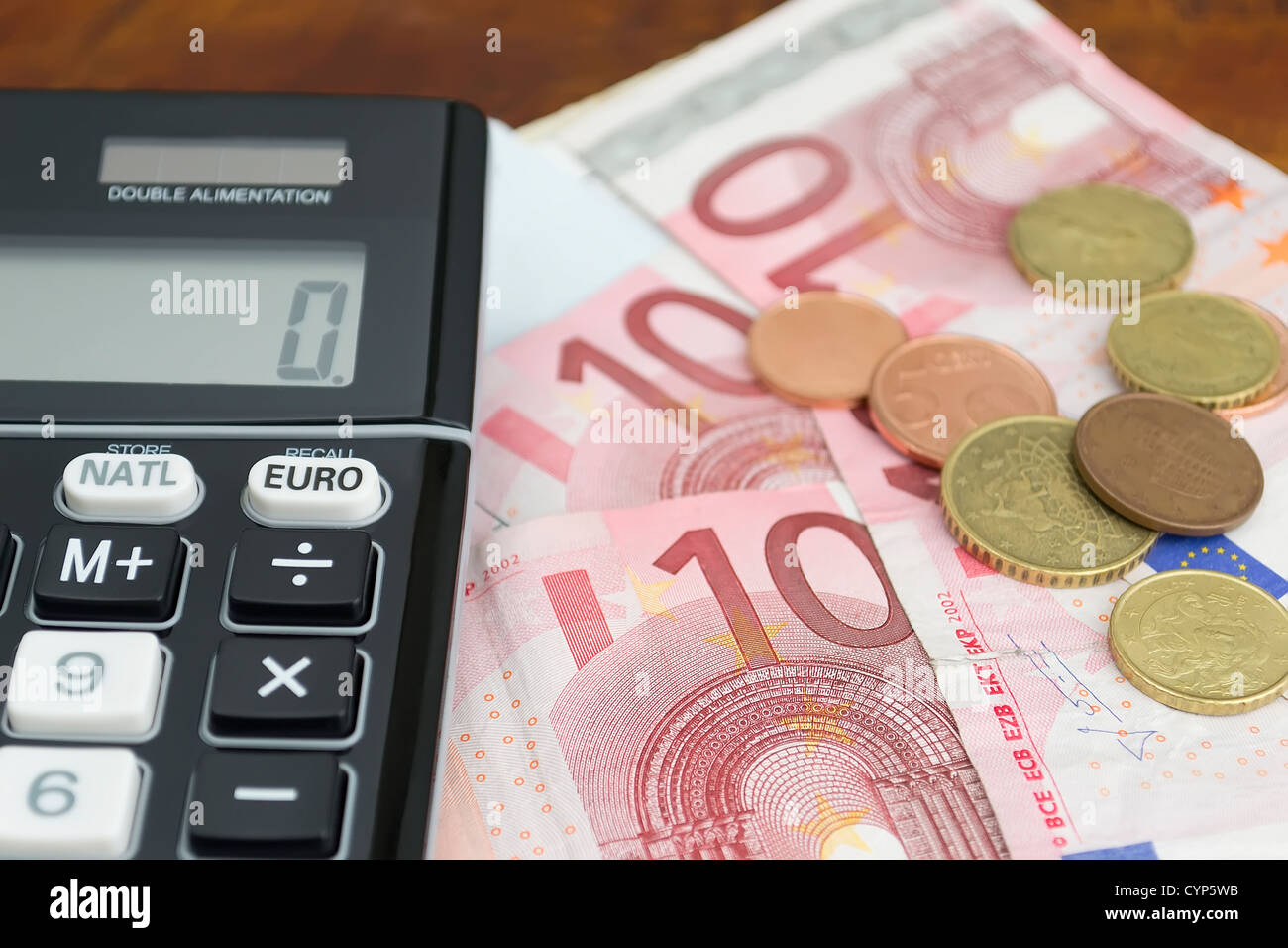 Convertidor de euros con billetes y monedas en euros en una mesa de madera  Fotografía de stock - Alamy