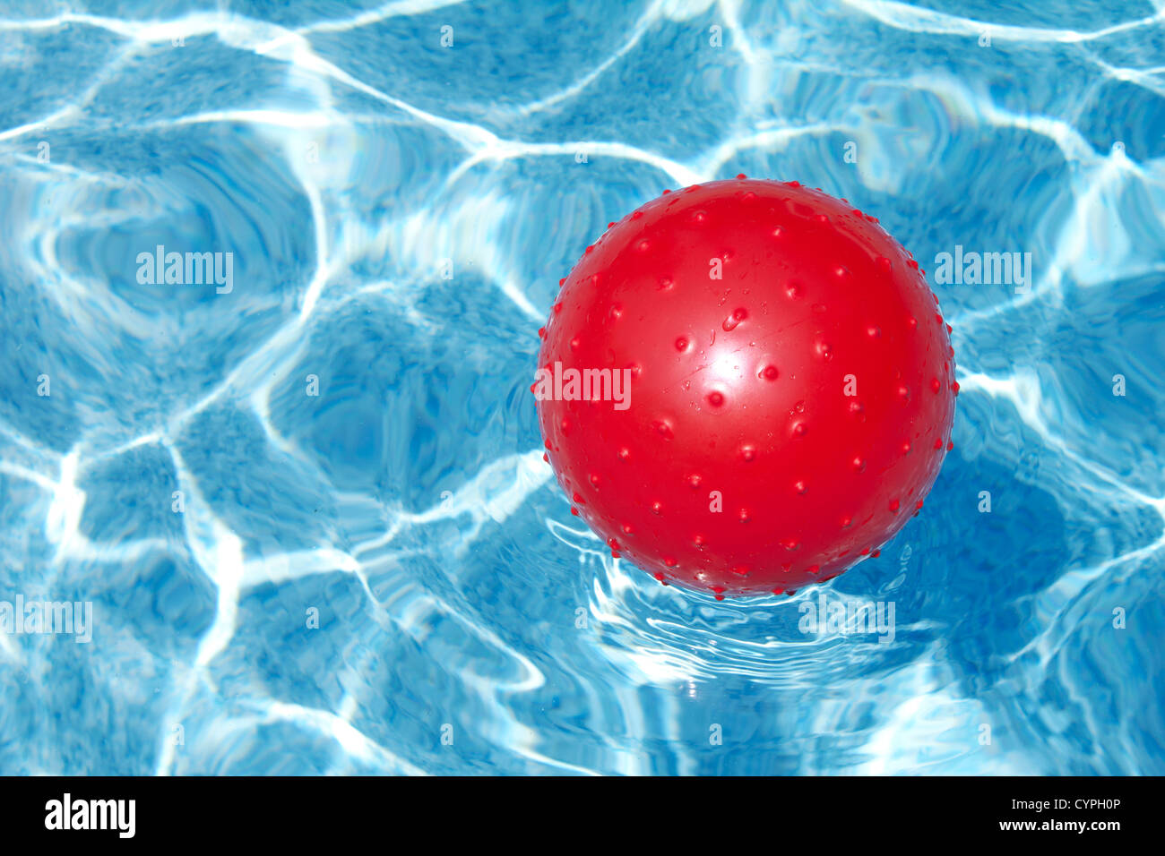 Bola roja flotando en la piscina Foto de stock