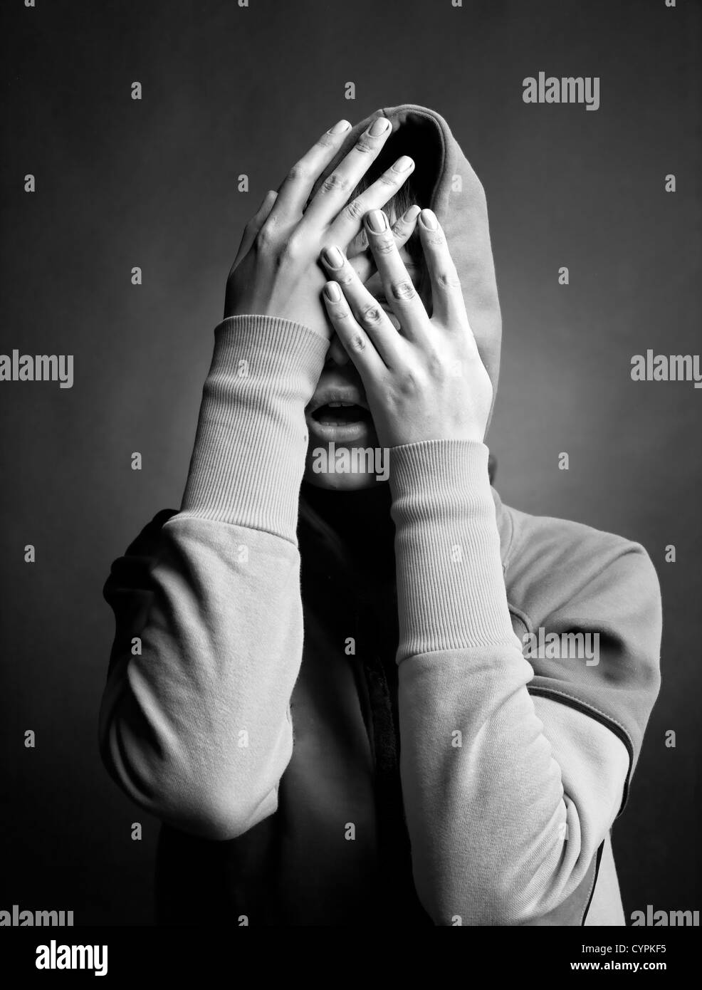 Mujer joven ocultar su rostro en sus manos Foto de stock