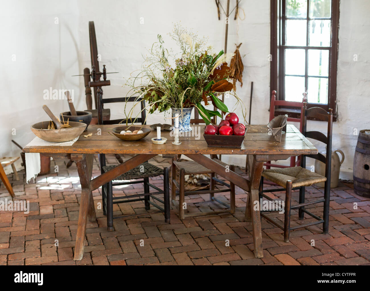 La mesa de la cocina colonial antiguo sillas alimentos y manzanas en sala blanca Foto de stock