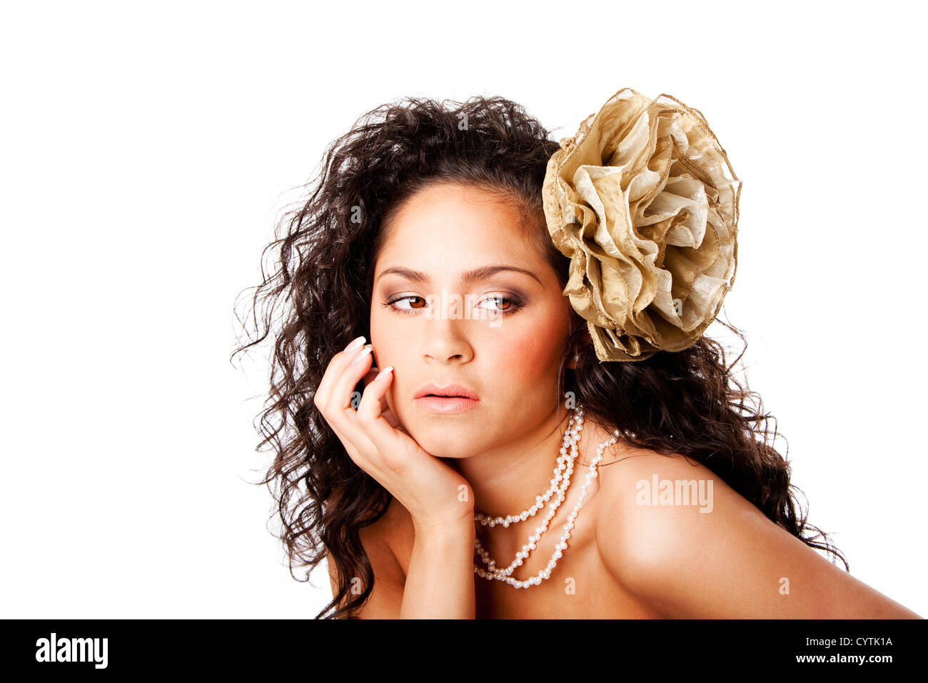 Hermoso rostro de una mujer hispana con caucásicos curtida piel clara, vistiendo un collar de perlas y una falsa flor en el pelo rizado Foto de stock