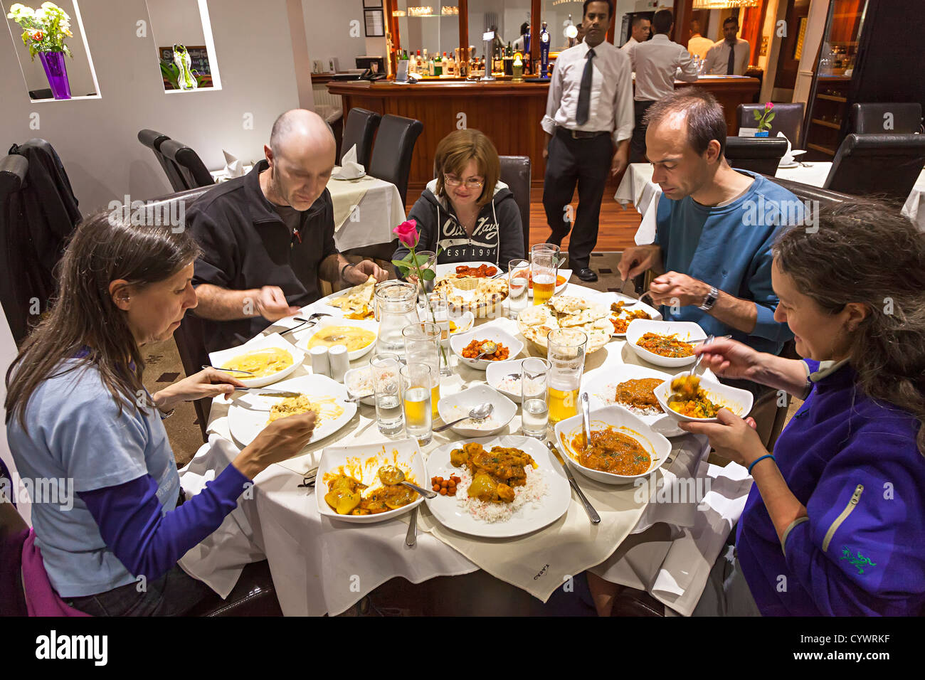 Grupo de gente comiendo curry en un restaurante indio, Burnley, Inglaterra, Reino Unido. Foto de stock