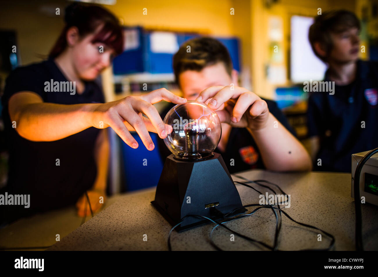 Los alumnos tocando una bolas de plasma aprender los principios de la física en una escuela general secundaria en Gales, Reino Unido Foto de stock