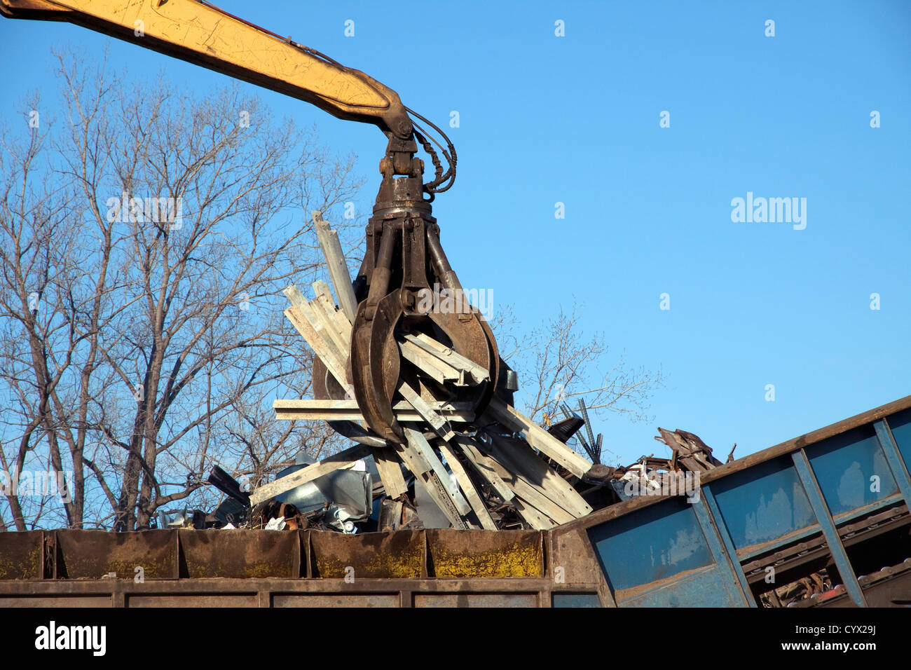 Lidiando grúa colocando objetos metálicos en Shredder en planta de reciclaje de metales e EE.UU. Foto de stock