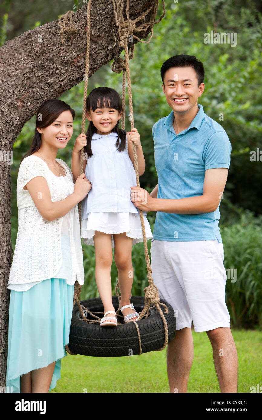 Familia feliz jugando en un columpio Fotografía de stock Alamy