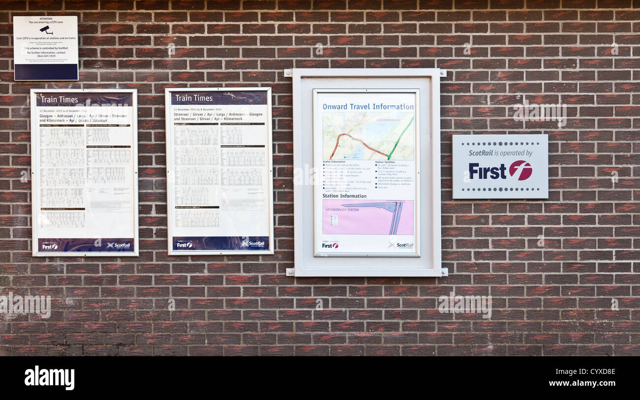 Horarios, mapas y avisos informativos en una estación de tren, la pared Lochwinnoch (Escocia, Reino Unido) Foto de stock