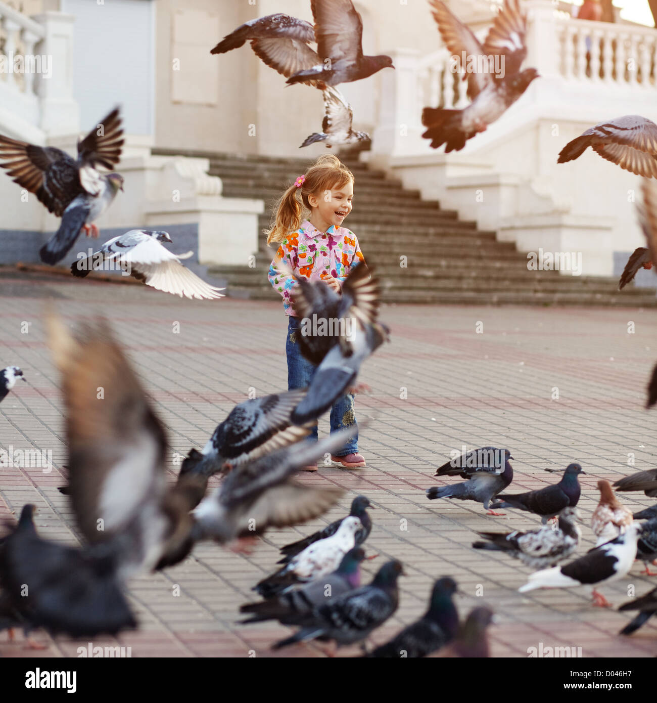 Niño jugando con palomas en las calles de la ciudad Fotografía de stock -  Alamy