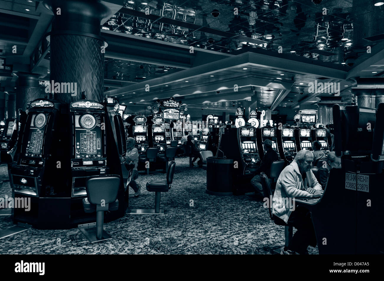 Los hombres sentarse apuestas en máquinas tragamonedas, Foxwoods Resort Casino interior, Ledyard, Connecticut, EE.UU. Foto de stock
