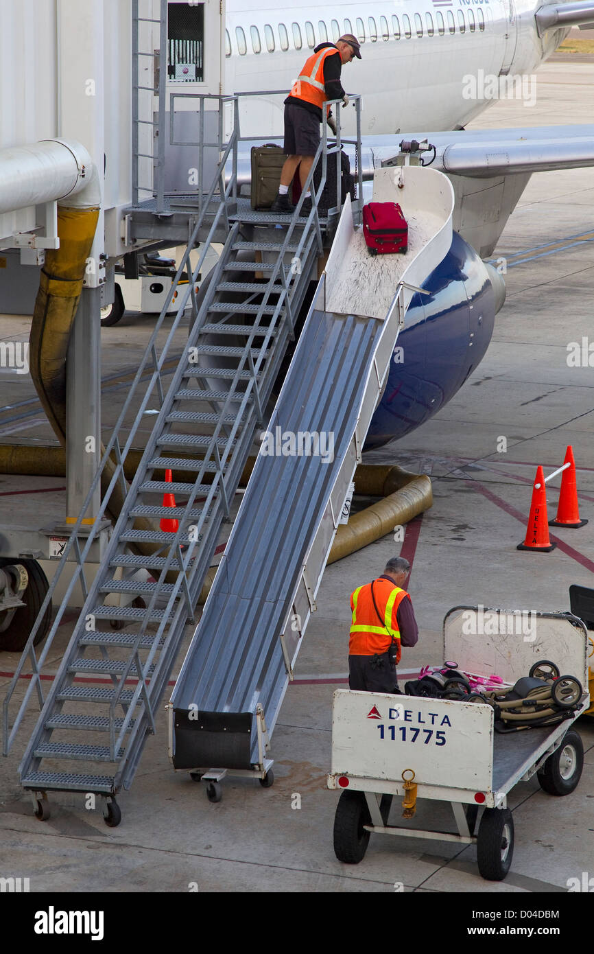 Dos aviones de carga de la tripulación del avión en el equipaje de asfalto Foto de stock