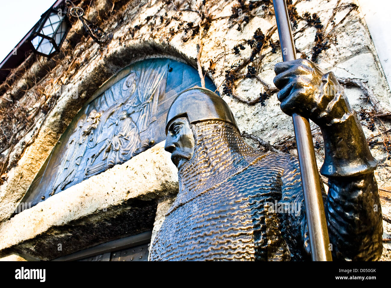 Guerrero de bronce medieval en frente de un castillo Foto de stock