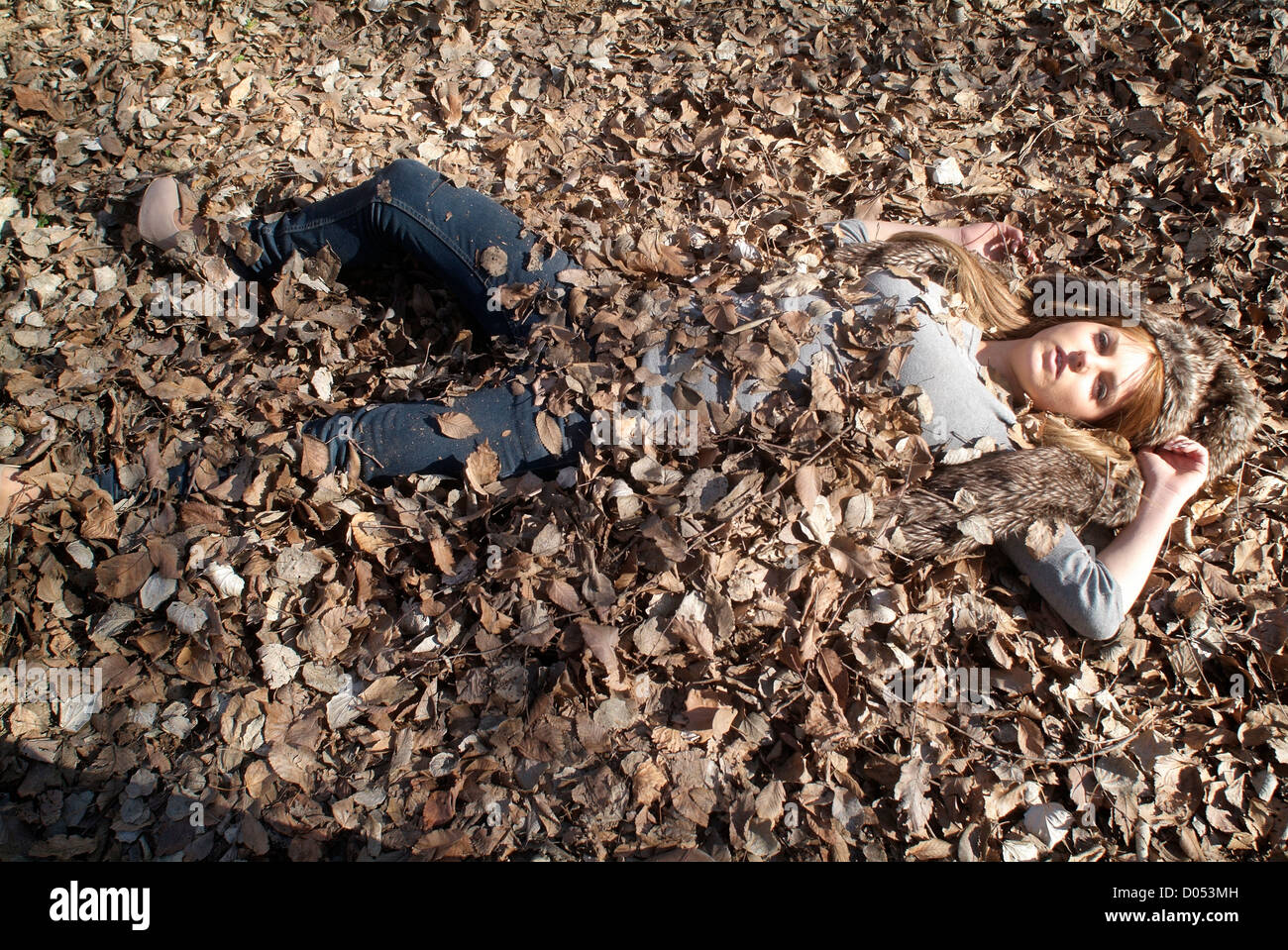 Mujer enterrado en hojas de roble Foto de stock