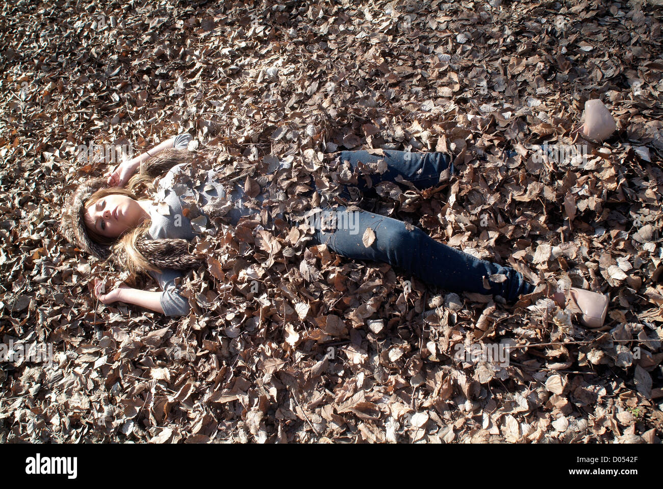 Mujer enterrado en hojas de roble Foto de stock