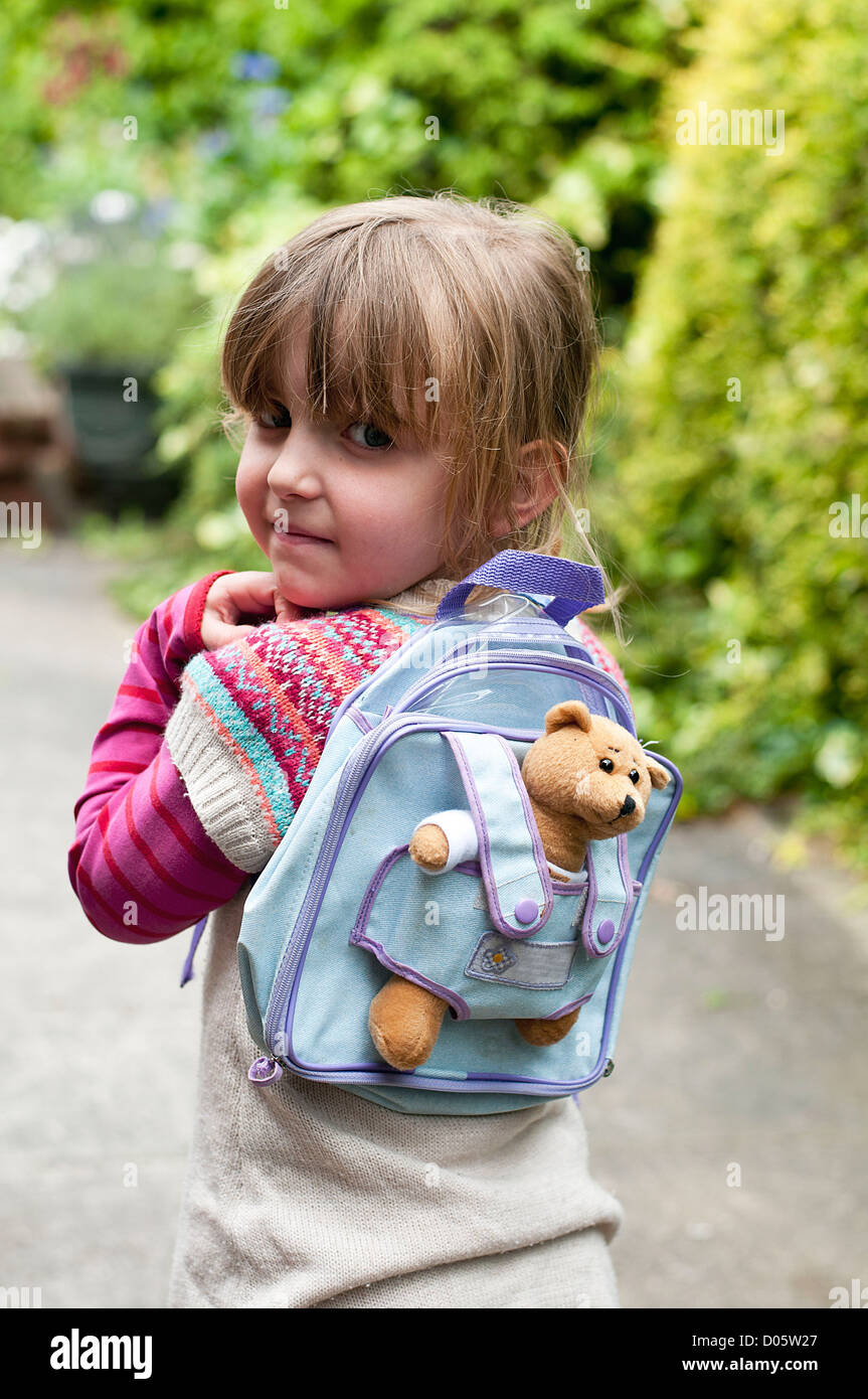 La pequeña niña fuera andando con un oso de peluche en la mochila  Fotografía de stock - Alamy