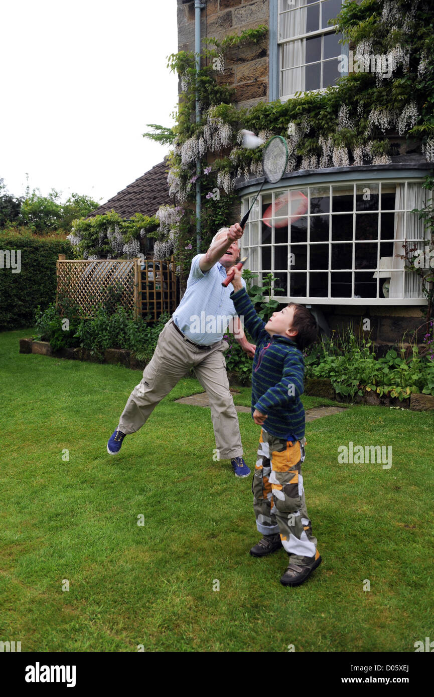 Abuelo jugar al bádminton en el jardín con su nieto en North Yorkshire, Reino Unido Foto de stock