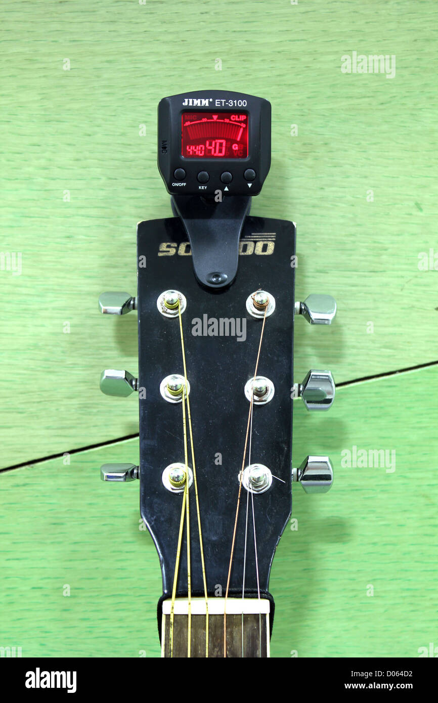 Un afinador eléctrico en una guitarra acústica Fotografía de stock - Alamy