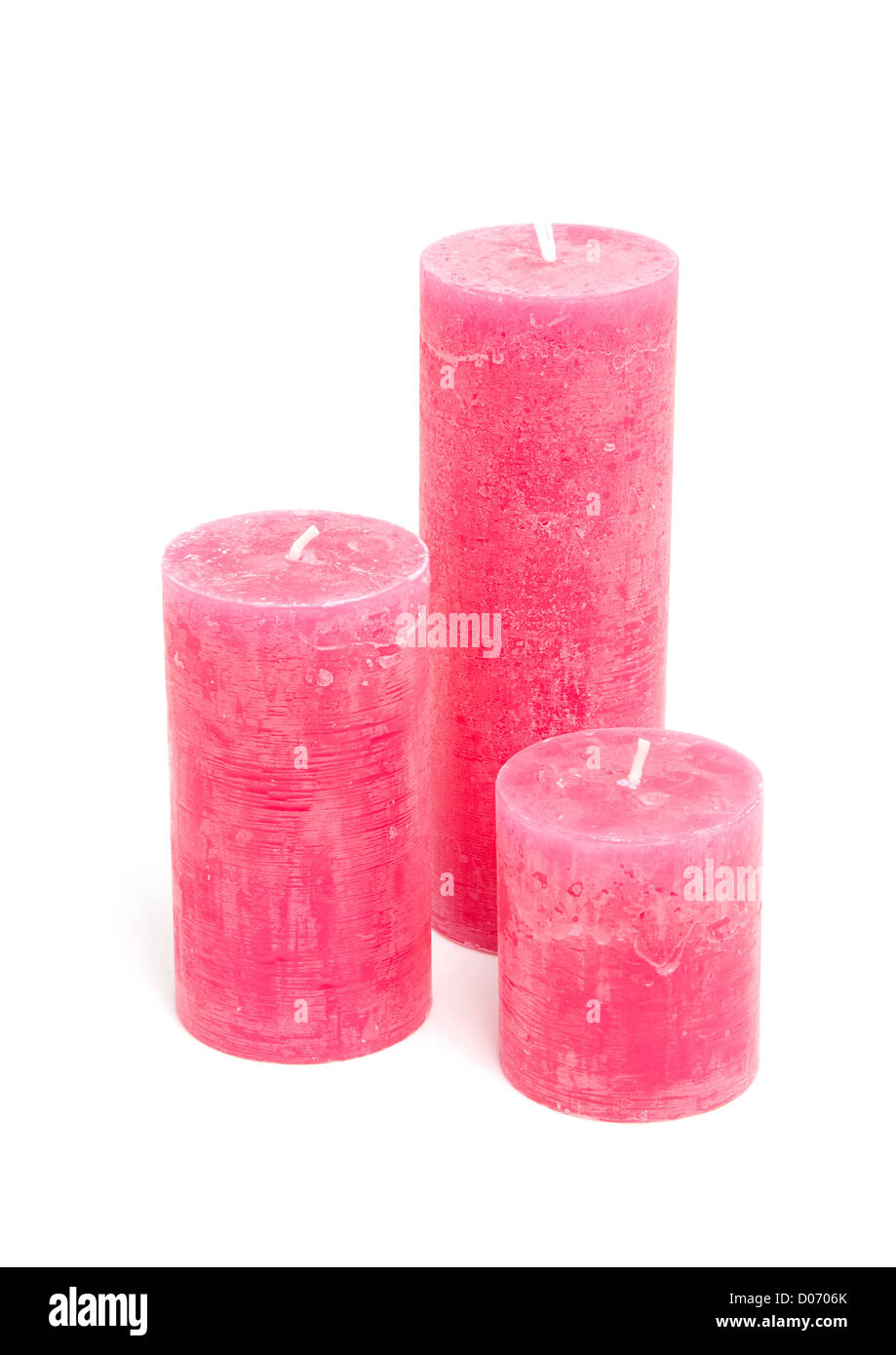 Tres velas rosa aislado sobre fondo blanco. Foto de stock