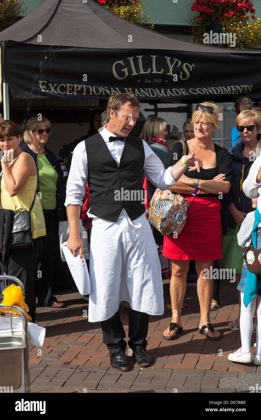 El hombre en traje de camarero entretenida a la multitud en la calle, Festival de Comida Abergavenny, Wales, REINO UNIDO Foto de stock