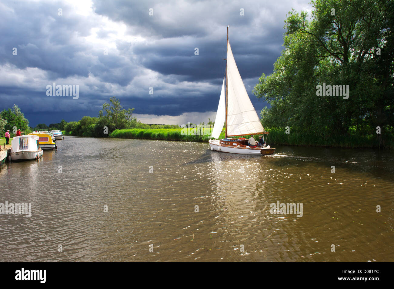 Navegando en el Norfolk Broads en verano con una tormenta moody sky Foto de stock