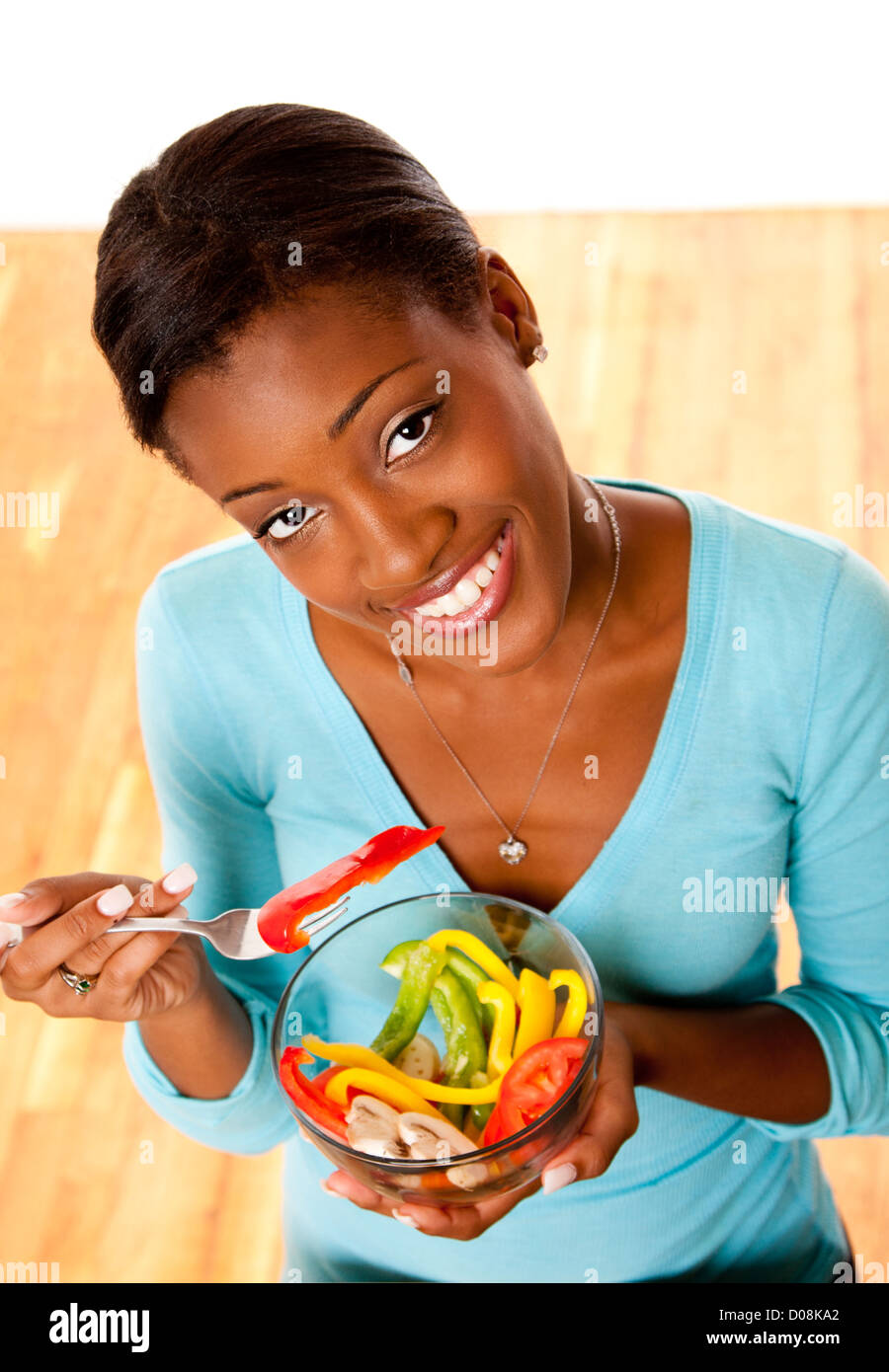 Bellos atractivos feliz sonriente joven conscientes de la salud comer ensalada saludable de un tazón. Foto de stock
