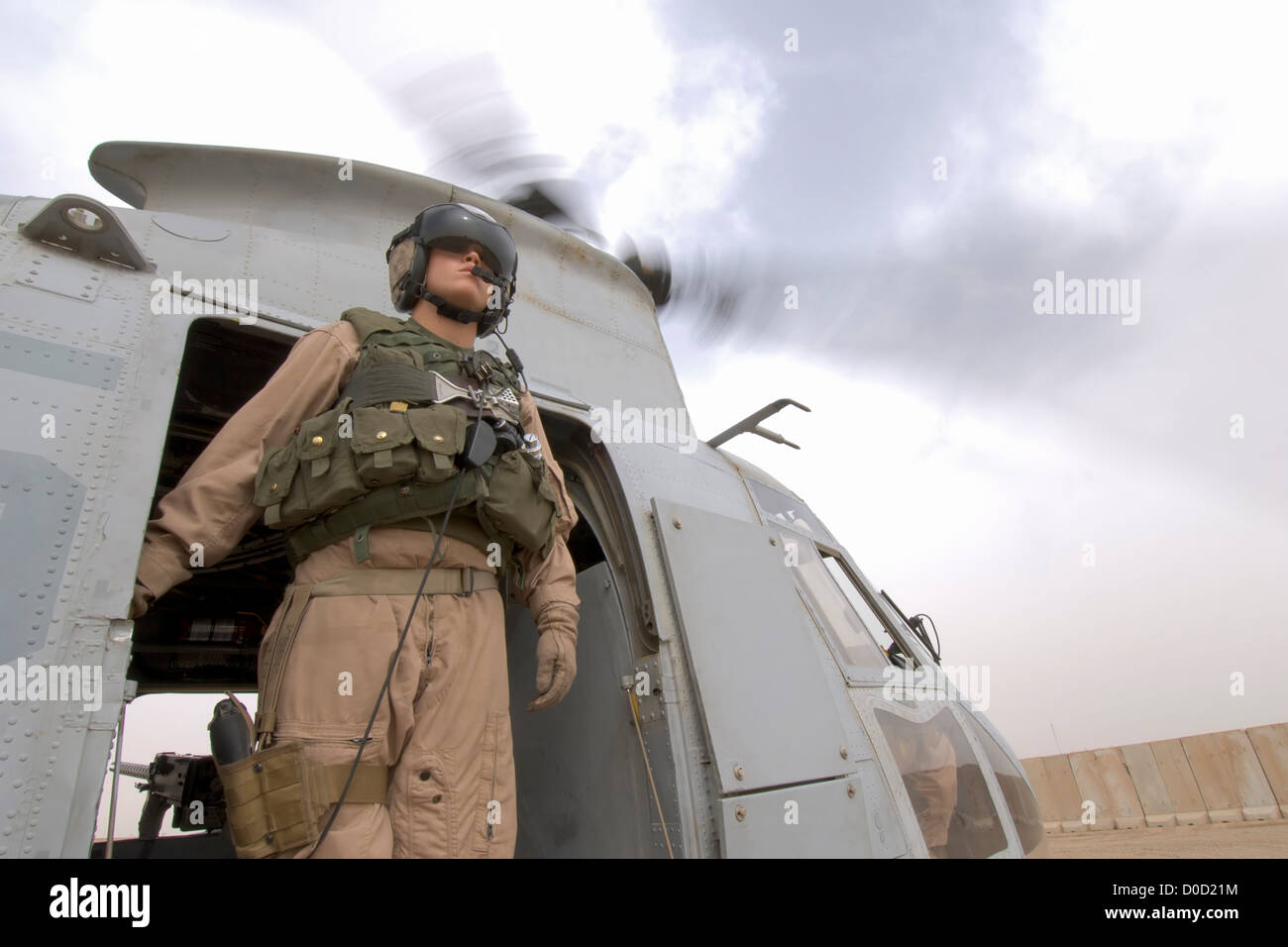 Jefe de la tripulación de un US Marine Corps helicóptero CH-46 Sea Knight analiza la distancia antes de una misión a Bagdad Foto de stock