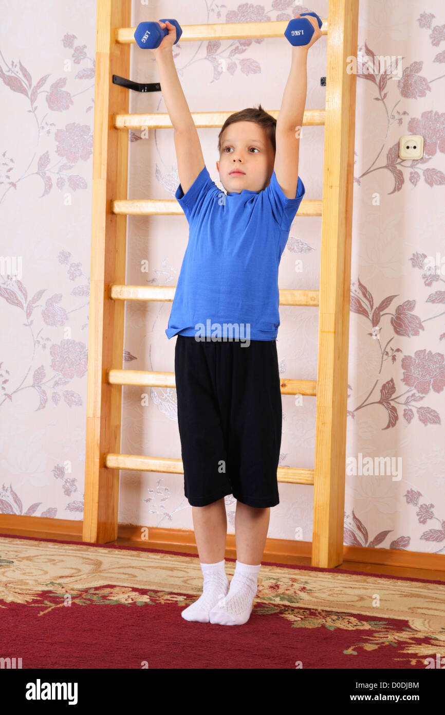 El niño preescolar levanta pesas en un hogar de Fatboy Foto de stock