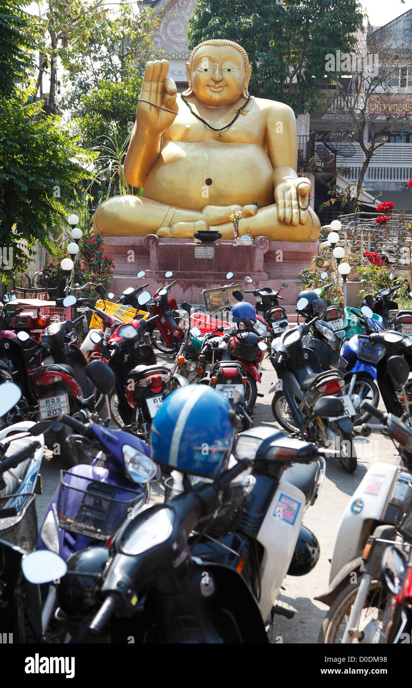 Estacionamiento para motos en frente de una gran estatua de Buda de oro, Chiang Rai, Tailandia, Asia Foto de stock