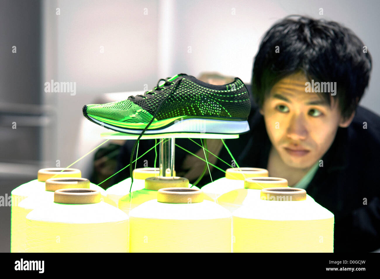 El 25 de noviembre de 2012, Tokio, Japón - un hombre ve la zapatilla Nike  Flyknit Racer por Nike, Inc. el premio Good Design Award 2012 muestra 1.180  buenos diseños productos seleccionados