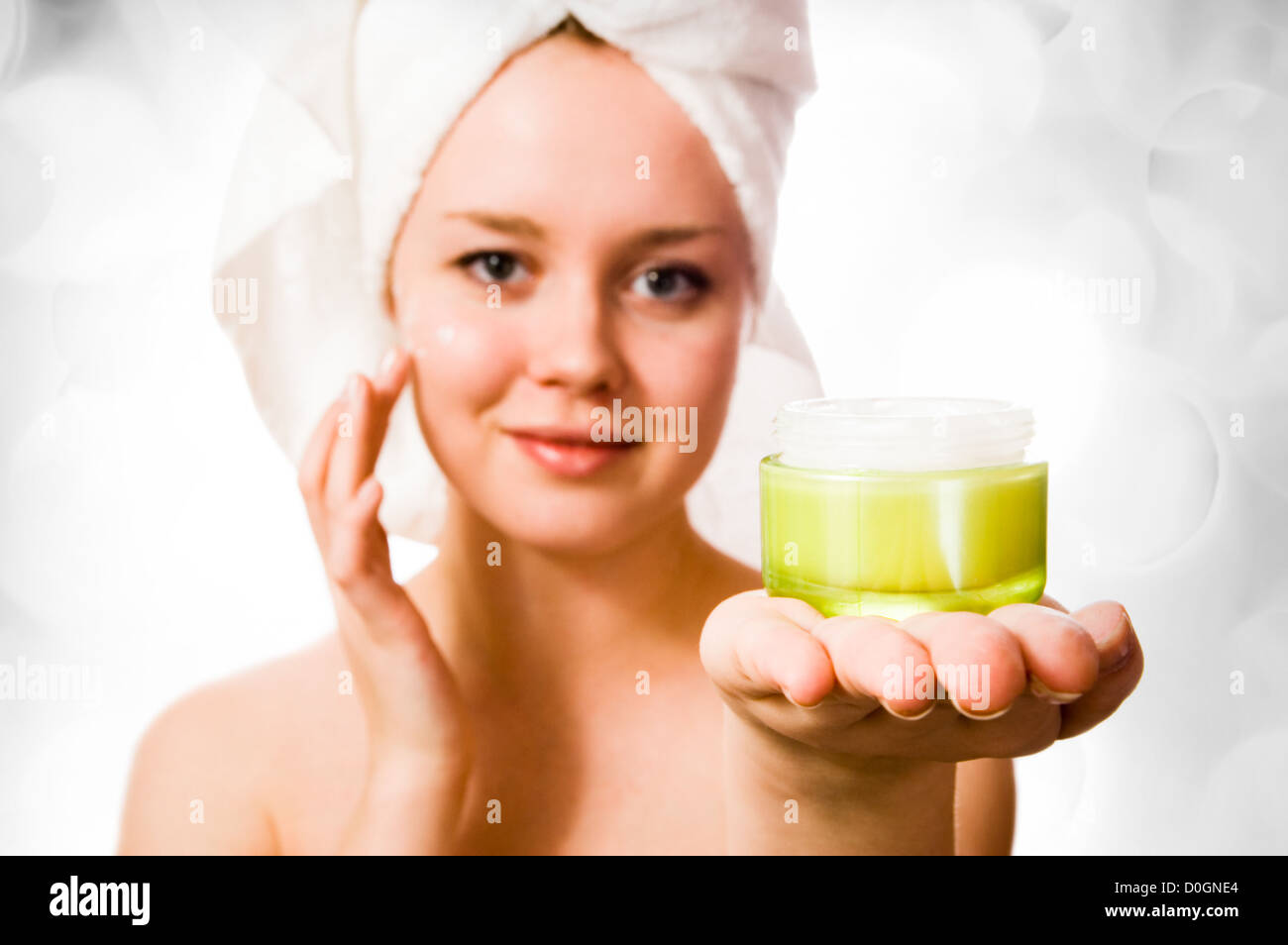 Niña con una toalla sobre su cabeza y crema. Foto de stock