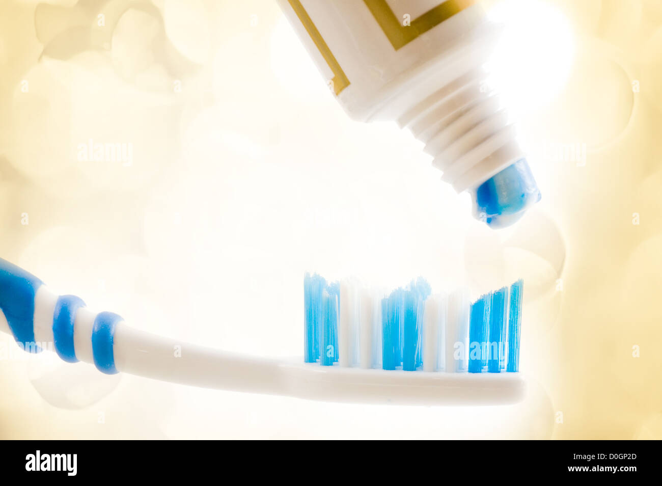 Cepillo dental y el tubo con la pasta con las luces en el fondo Foto de stock