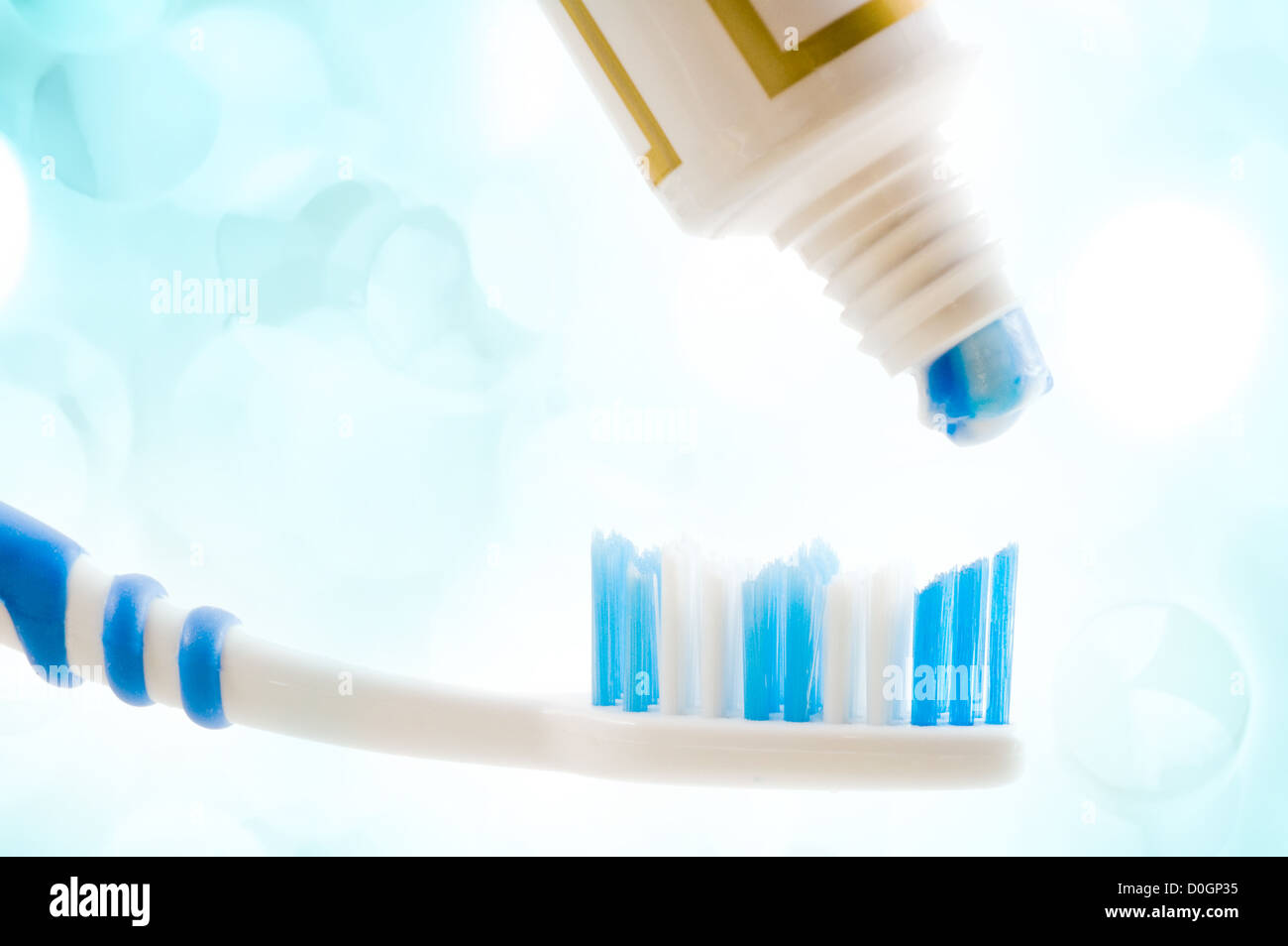 Cepillo dental y el tubo con la pasta con las luces en el fondo Foto de stock