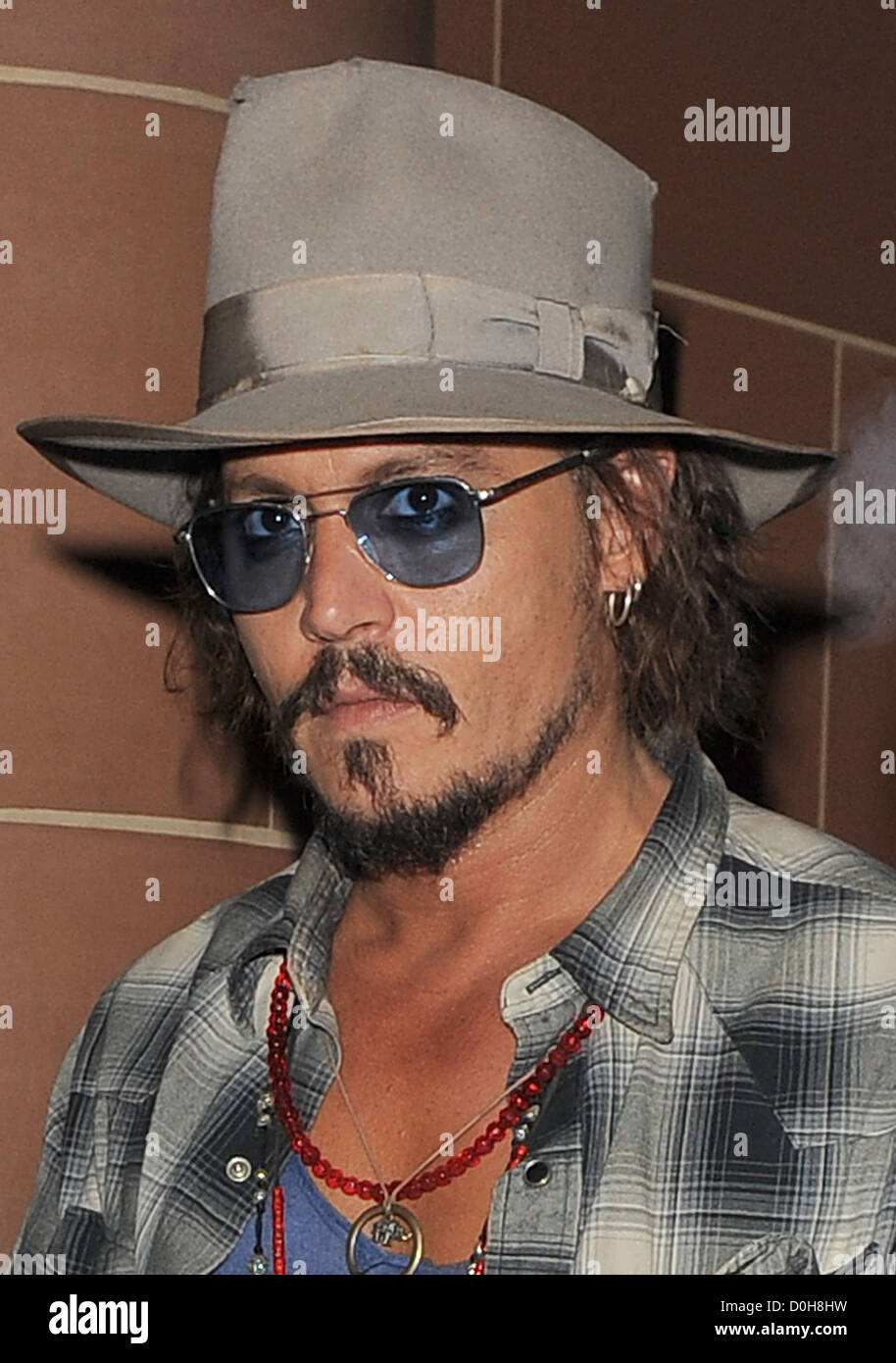 Johnny Depp, vistiendo un sombrero Fedora y gafas de sol, dejando a 'C'  restaurant de Londres. Depp fue el sporting algunos cortes en su rostro, y  un Fotografía de stock - Alamy