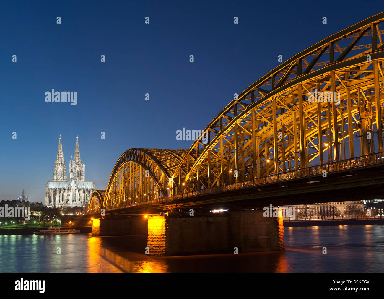 Vista de noche de la catedral de Colonia y el puente Hohenzollern a través del río Rin en Alemania Foto de stock