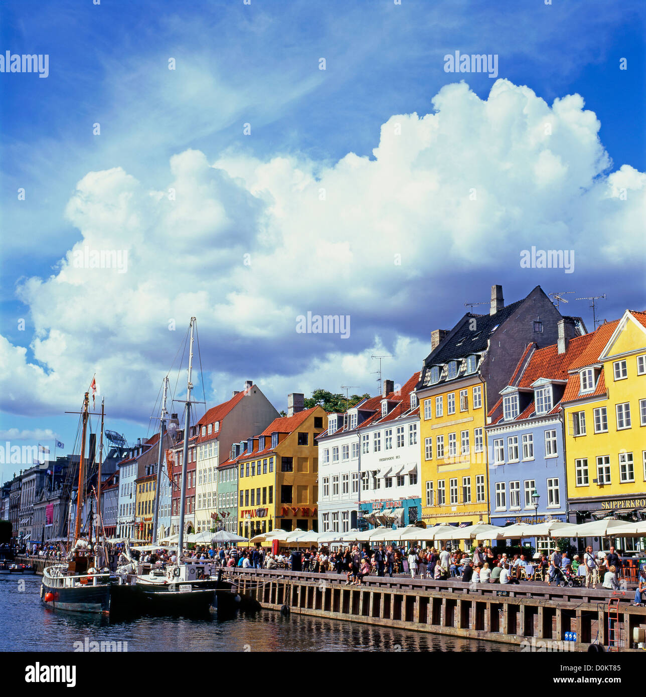 Nyhavn puerto en Copenhague Dinamarca con turistas, barco canal, edificios y dramáticas nubes cumulosas Europa UE KATHY DEWITT Foto de stock