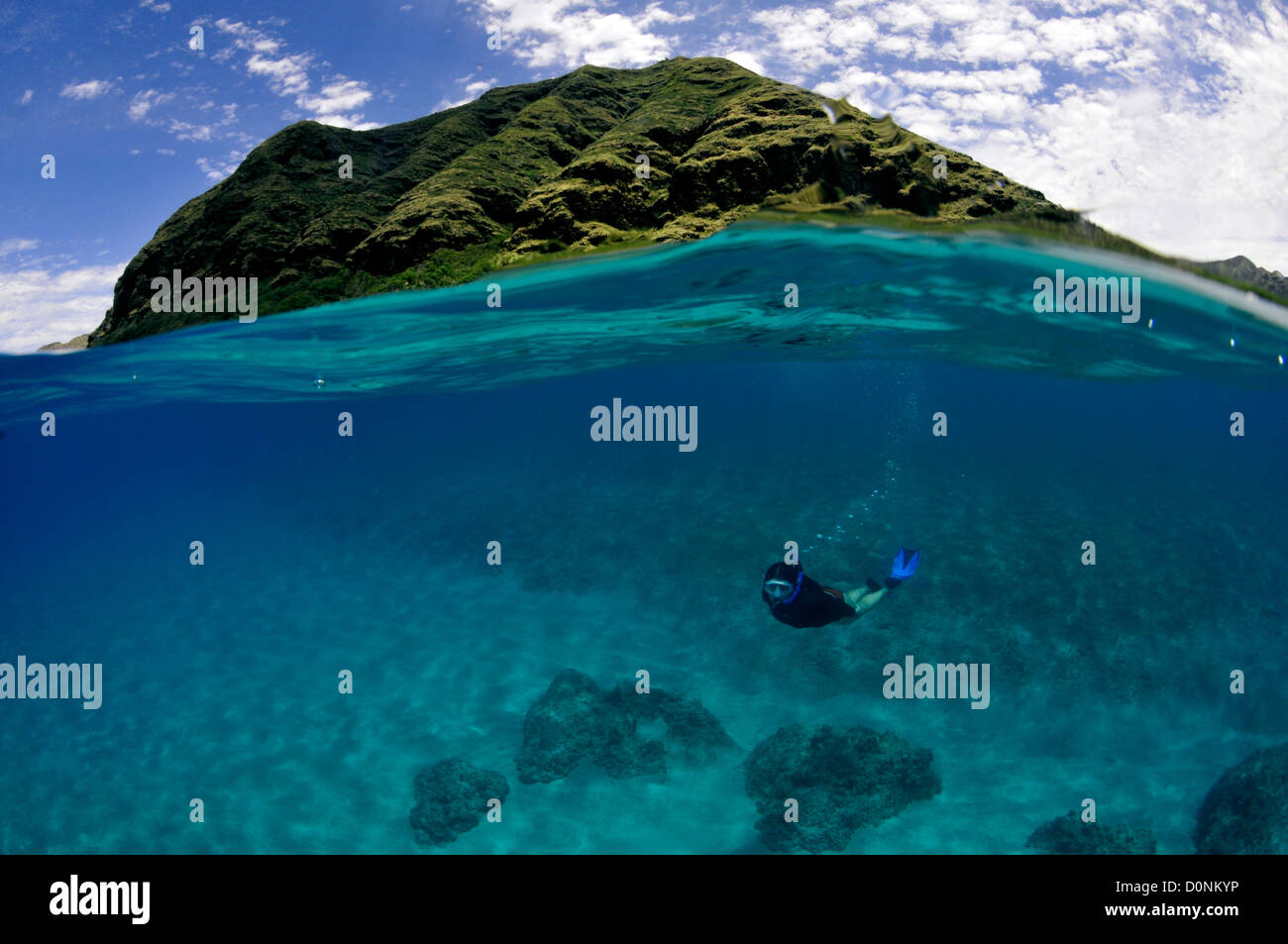 Imagen dividida de buceador y colina costera, la playa de Makua, Oahu, Hawaii, EE.UU. Foto de stock