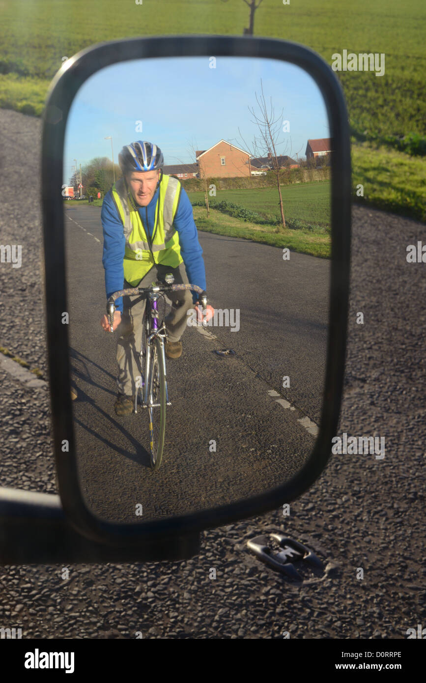 Ciclista vistiendo de alta visibilidad refleja en espejo de ala del vehículo en la carretera cerca de Leeds, Reino Unido Fotografía stock - Alamy