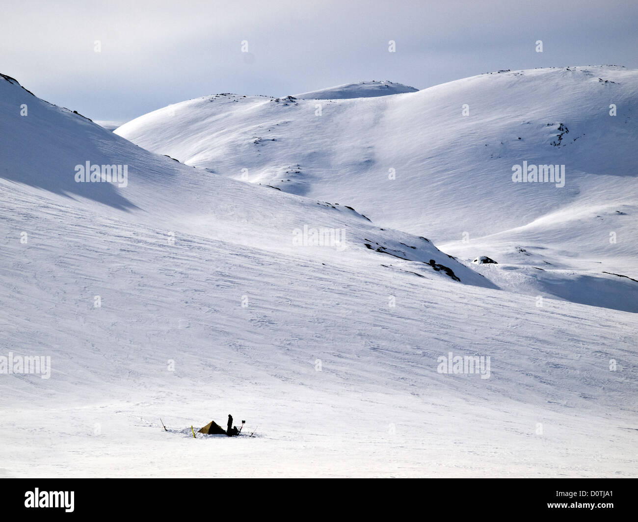 Cifra ascendía por una carpa en el desierto nevado, Hardanger ,Noruega Foto de stock