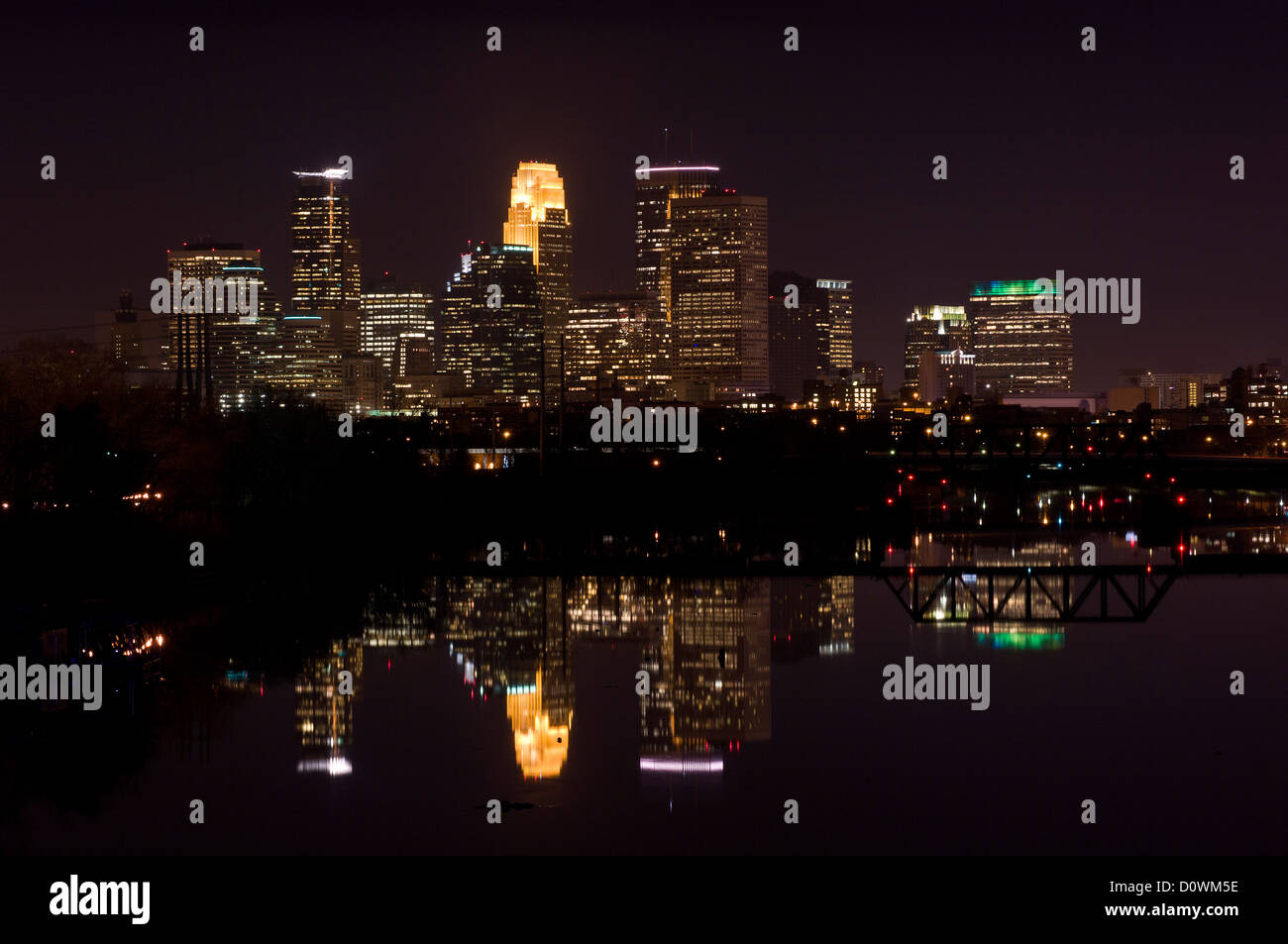 Perfil del centro de la ciudad de Minneapolis, Minnesota, en la noche con vistas del río Mississippi Foto de stock
