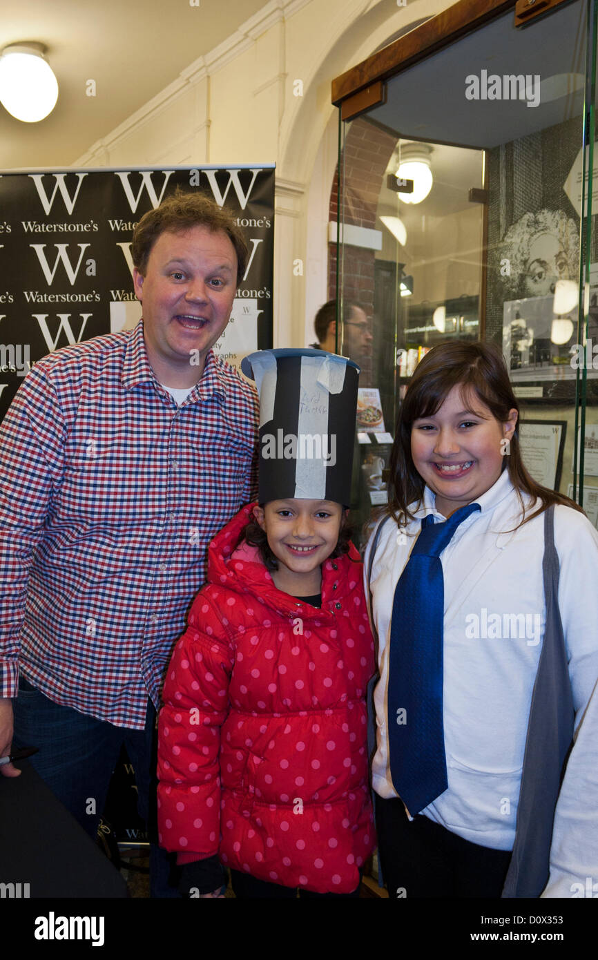 2 de diciembre de 2012. Waterstone's Bookstore, Reading, Berkshire, Reino Unido: Justin Fletcher, conocido infantil CBeebies BBC celebrity y autor, firma de libros en el centro de la ciudad tienda y posa con dos jóvenes aficionados. Foto de stock