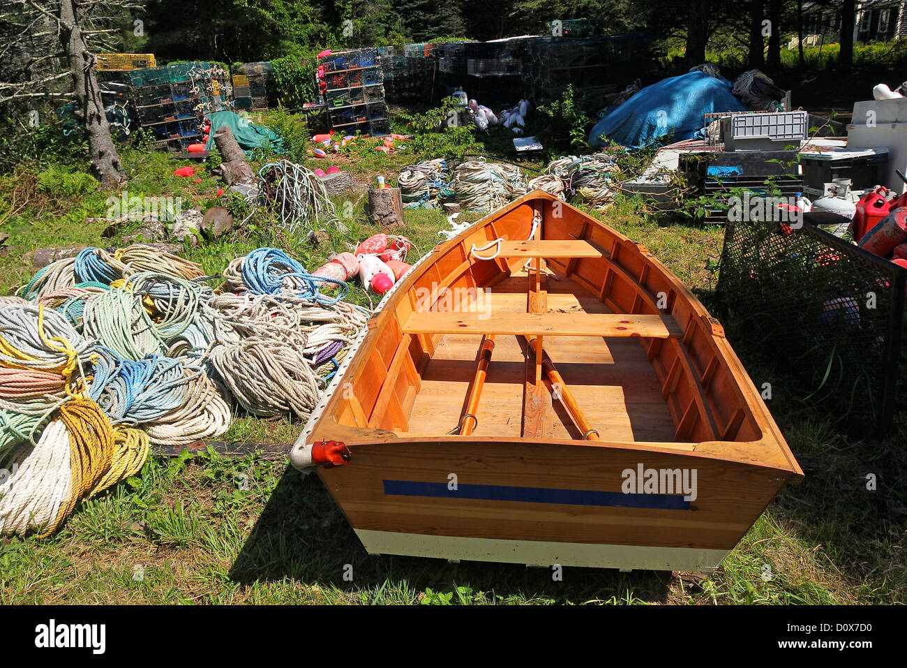 Un bote de remo, cuerdas y trampas en medio de árboles en la isla Monhegan, Maine Foto de stock
