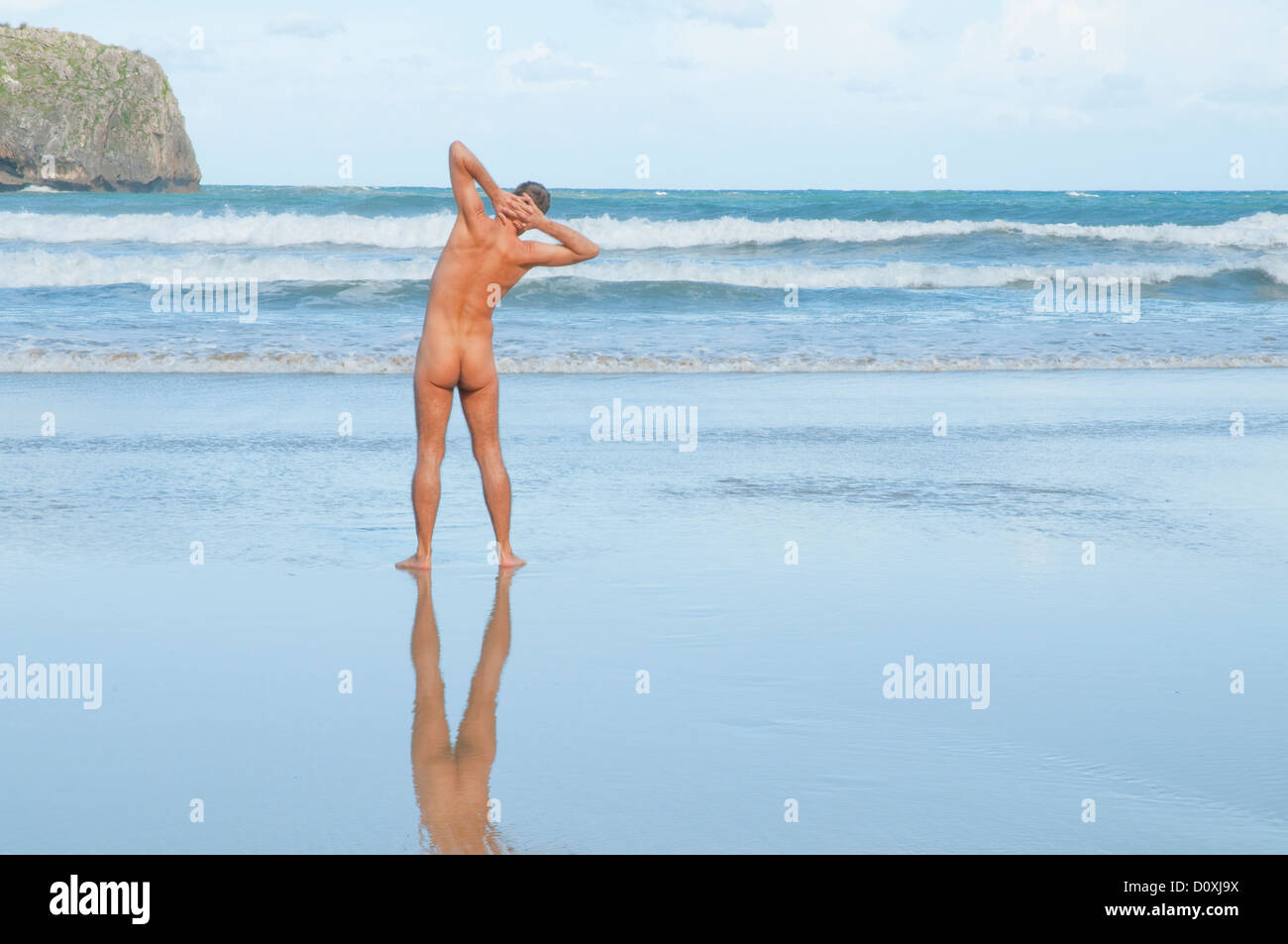 Hombre desnudo haciendo ejercicios en la playa. La playa de Torimbia, en  Asturias, España Fotografía de stock - Alamy