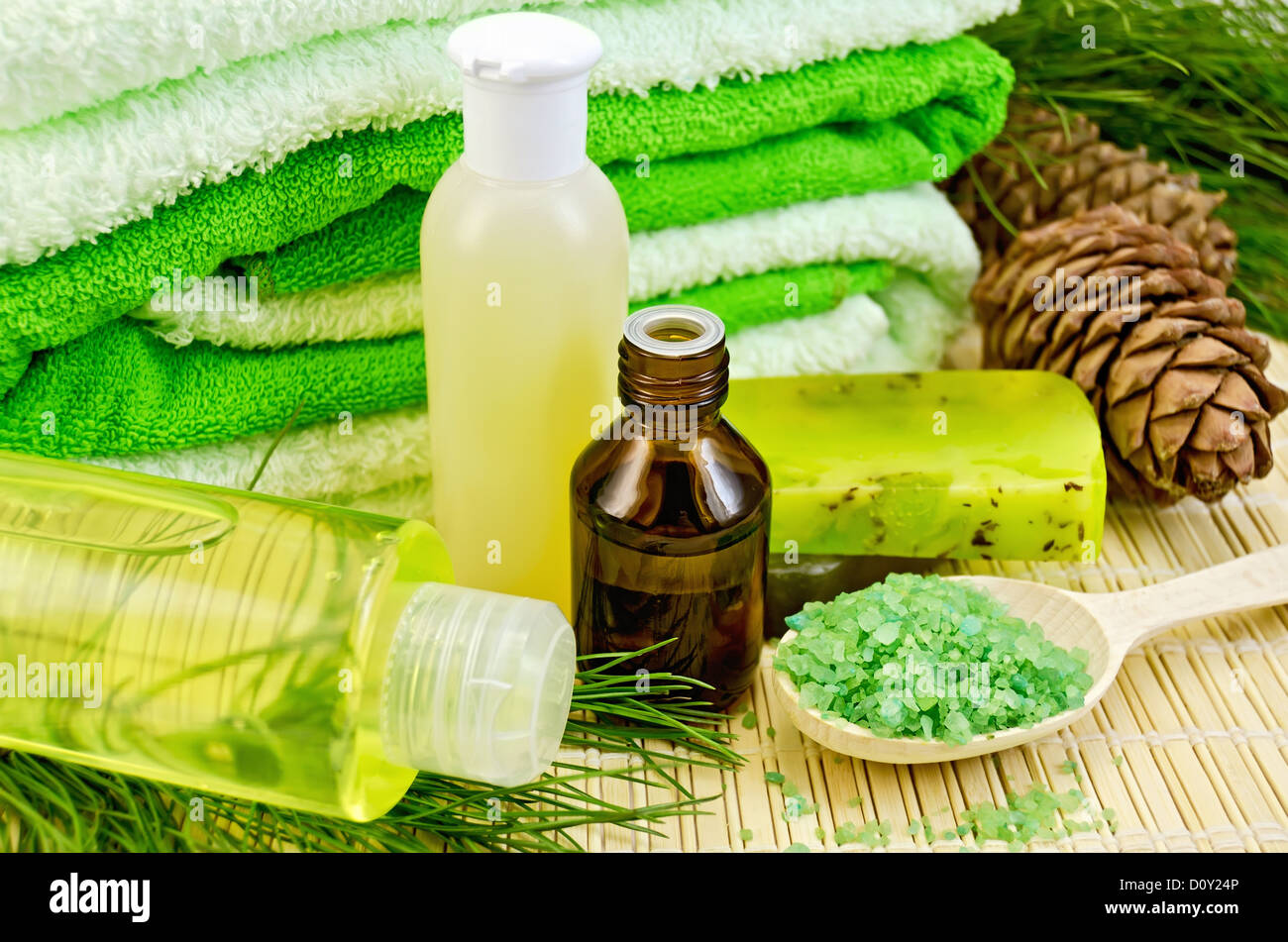 En una botella de aceite de cedro, conos, dos verdes jabón casero, toallas,  sal, loción, gel de ducha sobre una estera de bambú Fotografía de stock -  Alamy