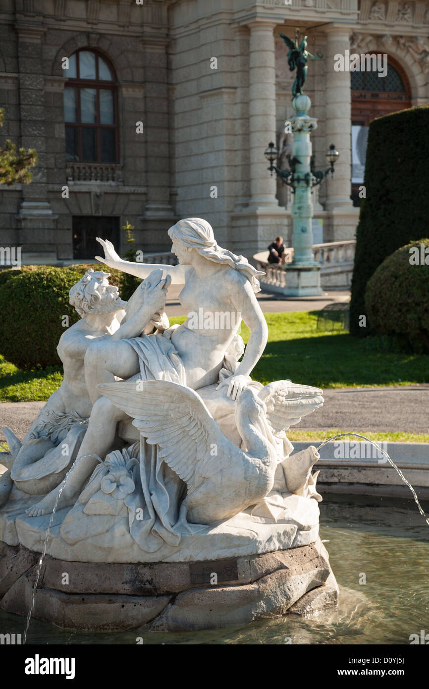 Fuente de mármol ornamentado fuera de Viena el Kunsthistorisches Museum con el hombre libro de lectura en el sol en gran balaustrada detrás. Foto de stock