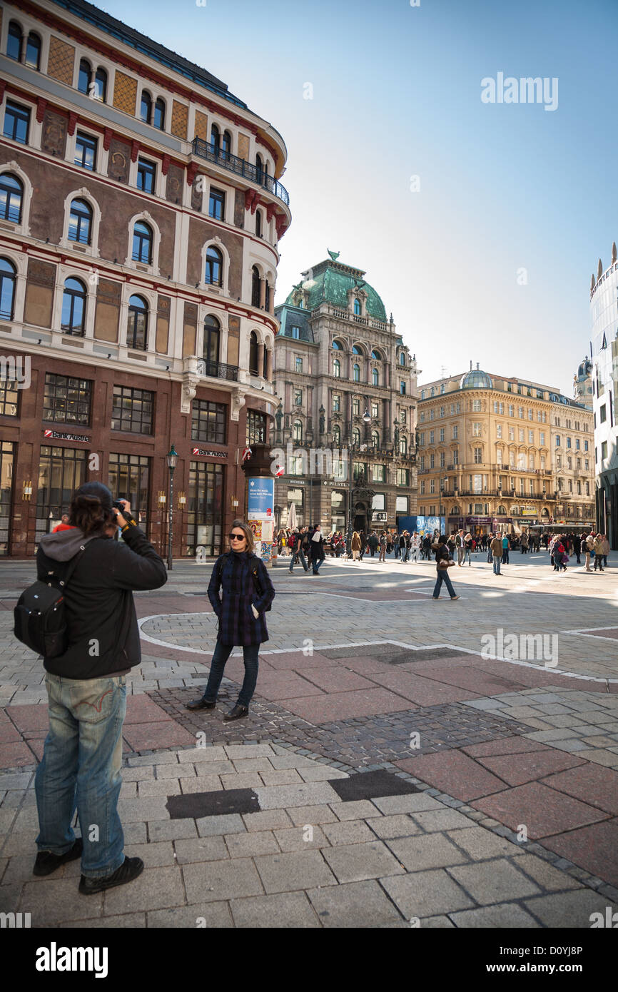 Una joven mujer plantea que su foto tomada en Stephansplatz, Viena, ornados edificios antiguos detrás de ella. Foto de stock