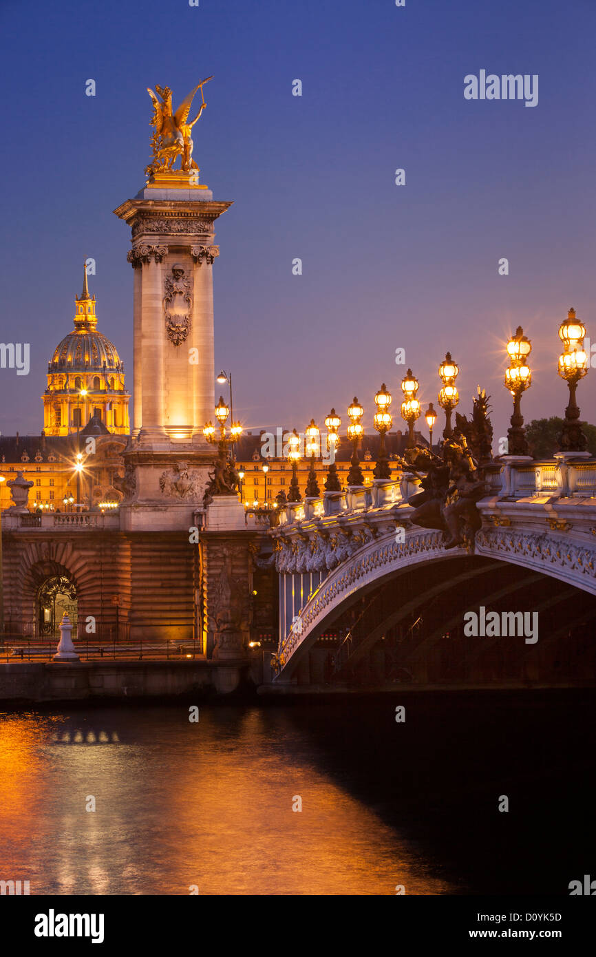 Pont Alexandre III sobre el río Sena con la cúpula del Hotel des Invalides más allá, París Francia Foto de stock