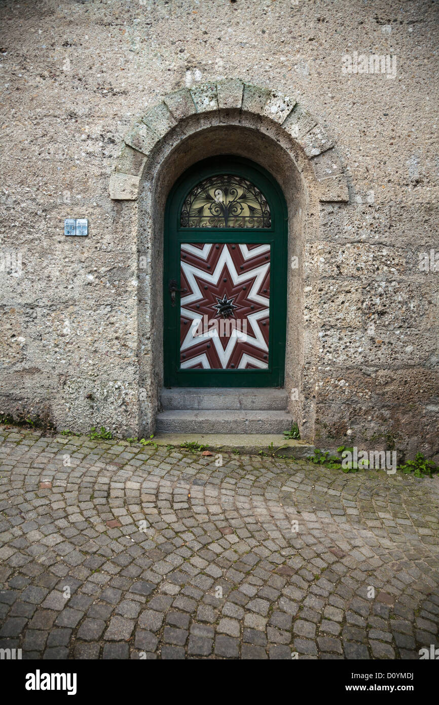 Y con arcos decorativos puerta roja y blanca a Salzburgo's Stieglkeller situado en una gran pared de piedra con calles empedradas. Foto de stock